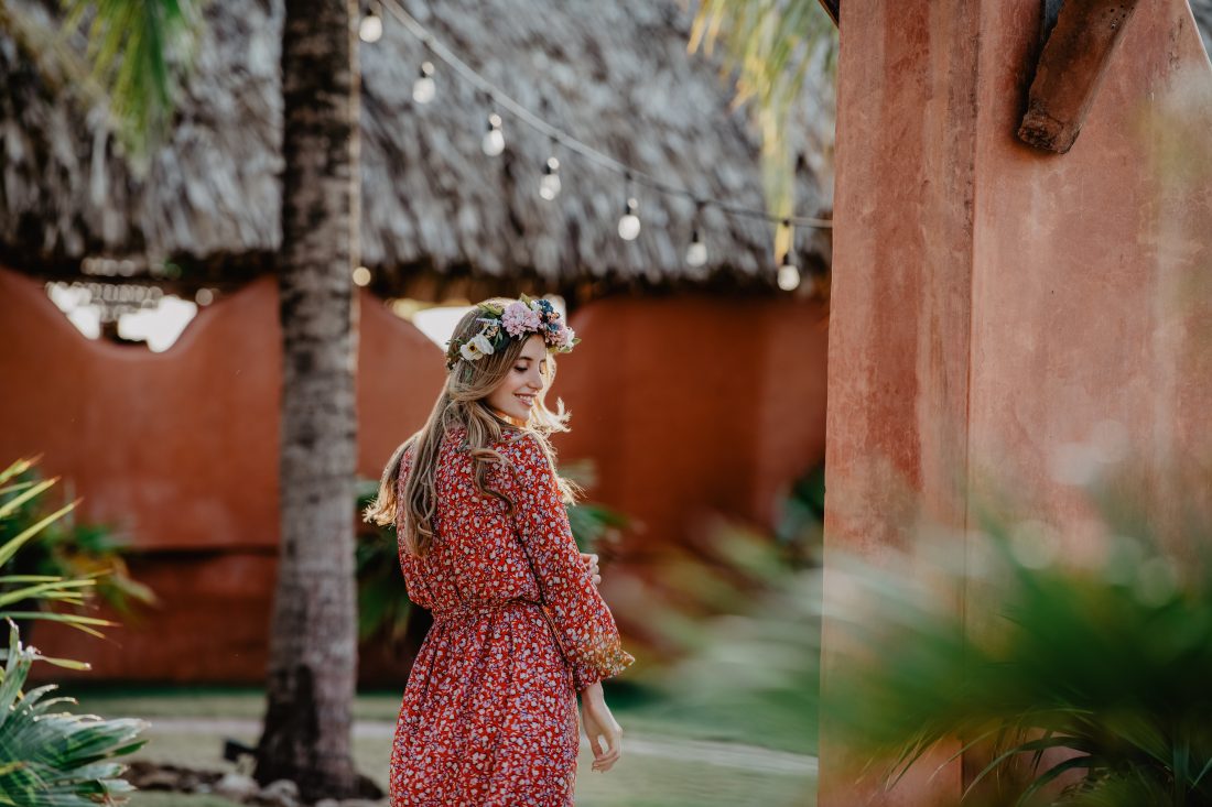 Eine junge Frau mit Blumenkranz von Trisa Accessoires und Blumen Kleid