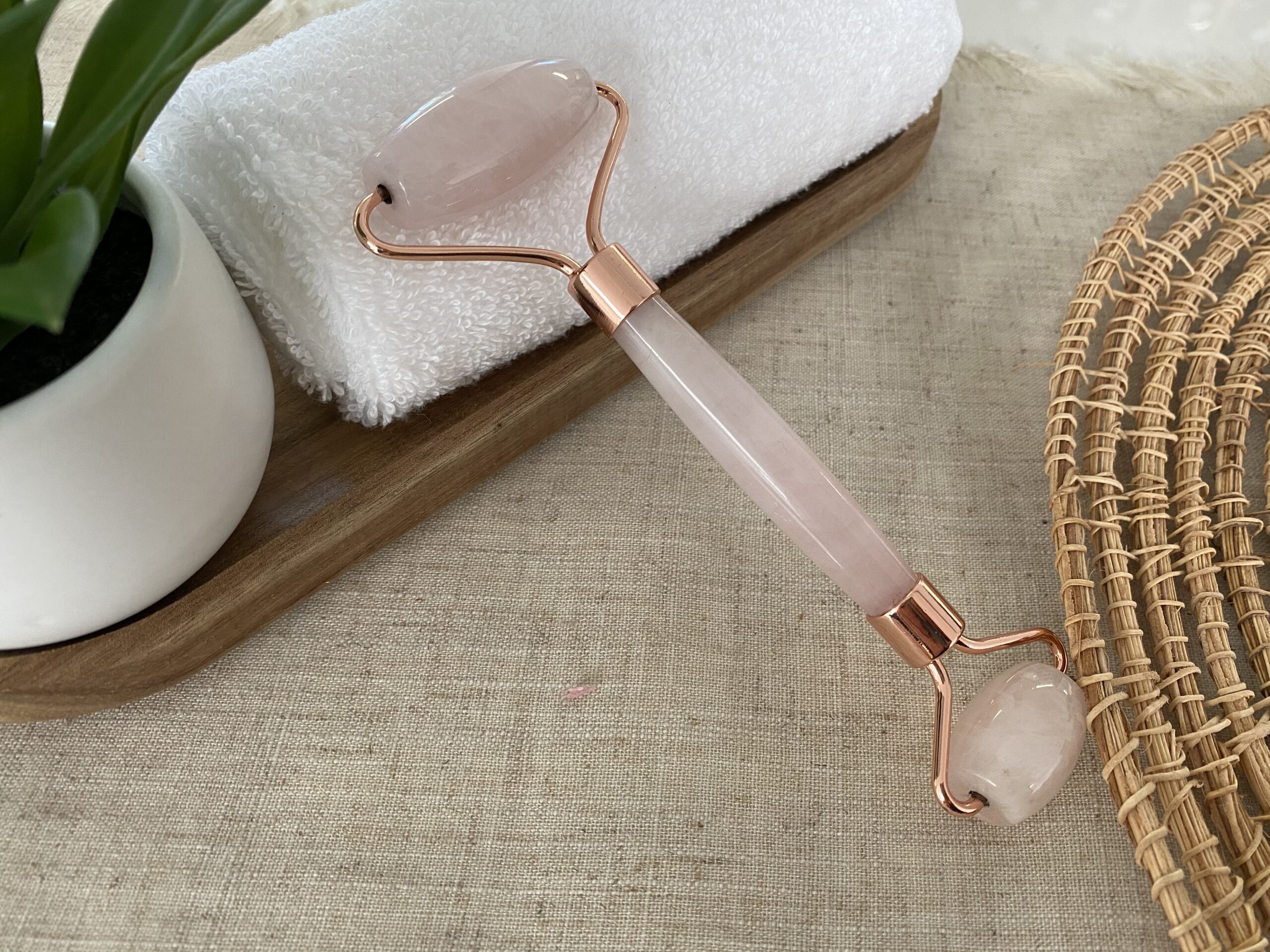 Rosenquarz Gesichtsmassage Roller Roségold Flat Lay natural auf schönem Hintergrund