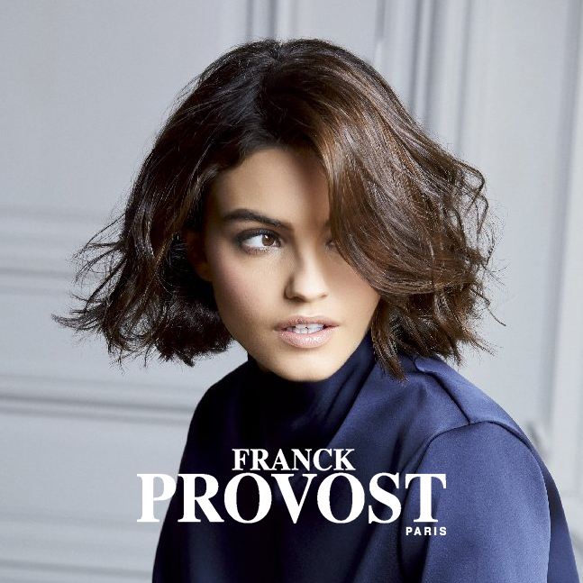 Eine junge Frau mit gewellten Haaren, pflegt ihr Haar mit den Produkten XPERT PRO von Franck Provost.