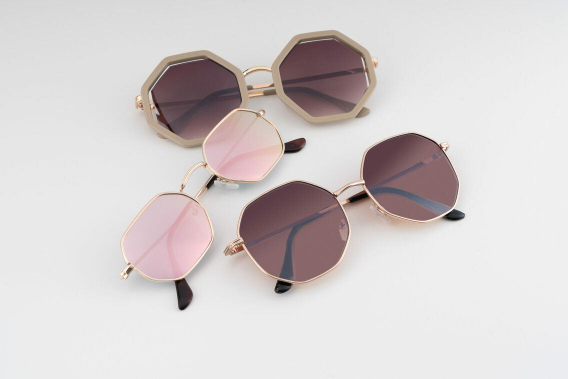 Drei hexagonale Sonnenbrillen mit getönten Gläser von Trisa Accessoires auf weissem Hintergrund.