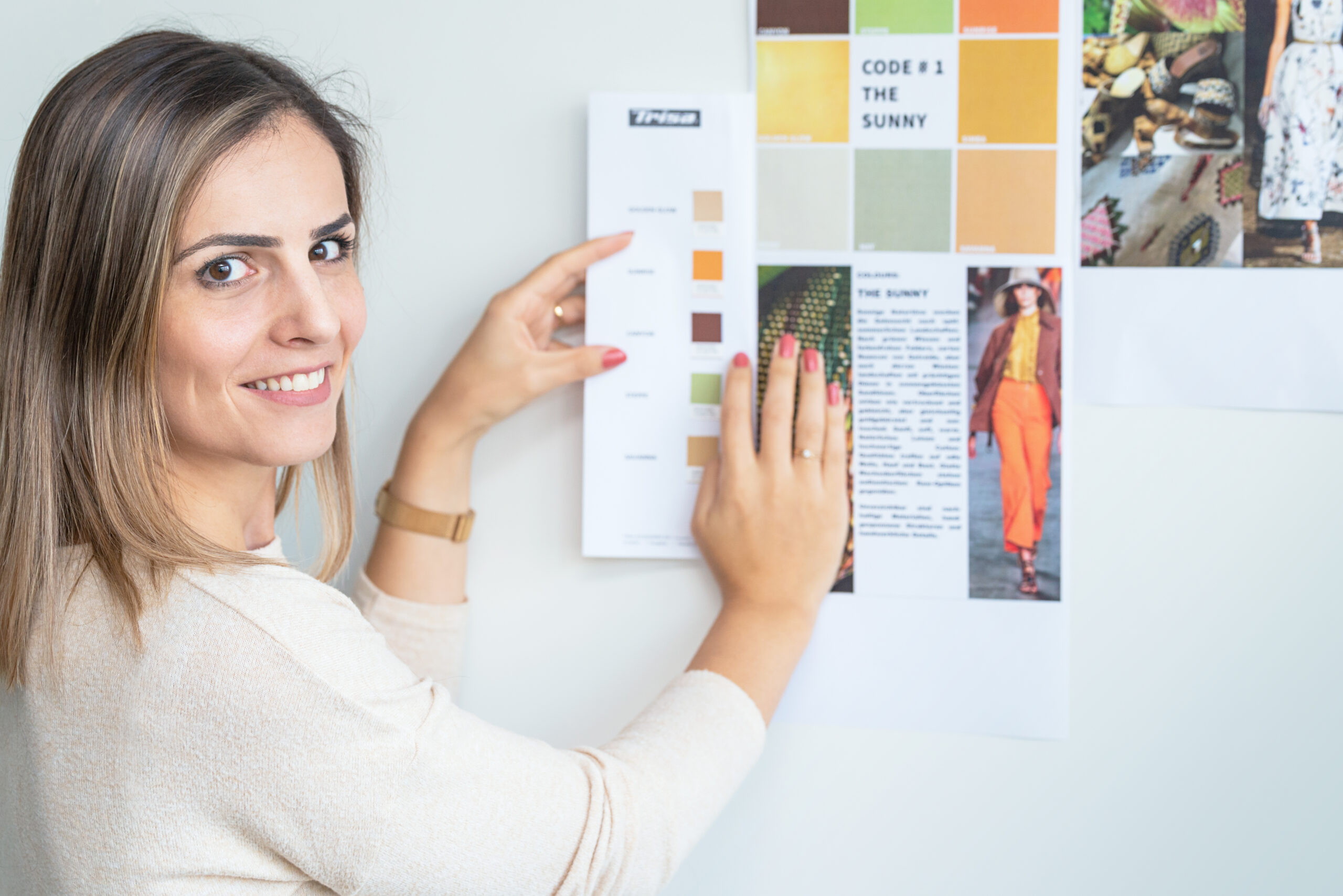 Junge Frau bei der Sortimentsgestaltung einer Haarschmuck Linie von Trisa Accessoires, vor weisser Wand